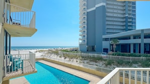 Una piscina con vistas a la playa y un edificio alto al fondo.