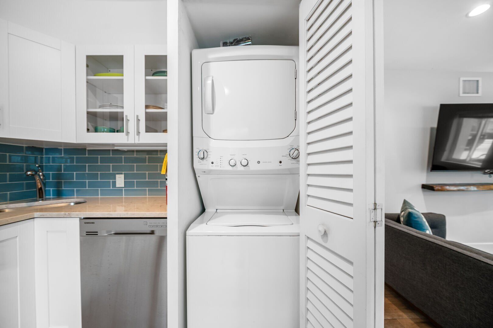 A compact kitchen with a dishwasher, a washing machine, and a microwave.