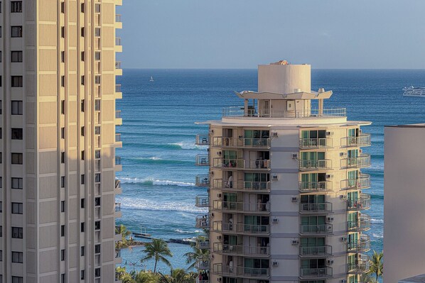 Un hotel de varios pisos con balcones con vista al océano, que presenta un diseño moderno y vistas despejadas al mar.