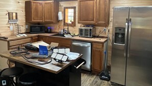 A kitchen with wooden cabinets, a microwave, a toaster, a refrigerator, a sink, and a dishwasher.
