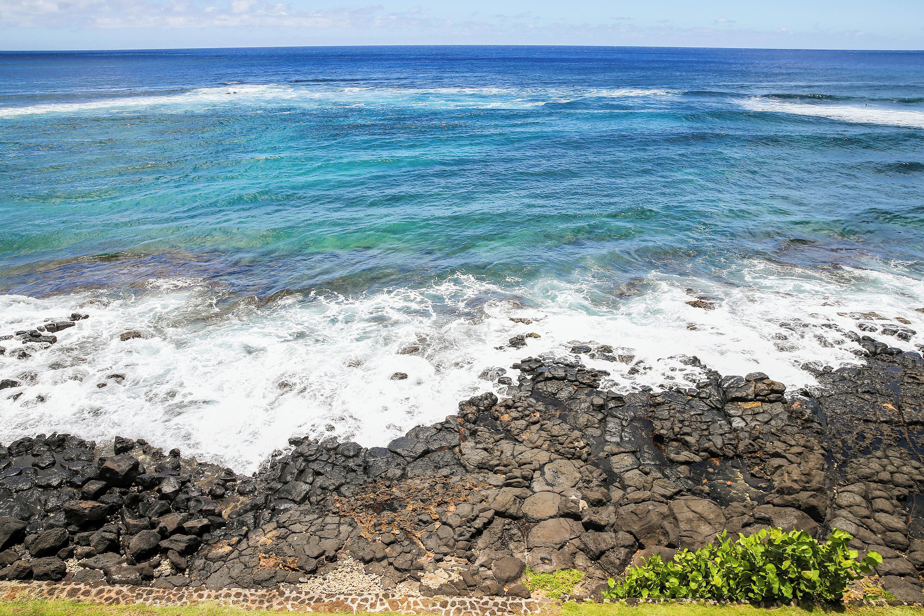 A rocky shoreline with clear blue ocean waves.