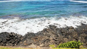 Un littoral rocheux bordé par des vagues d’un bleu azur.