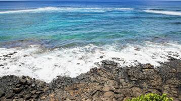 A rocky shoreline with clear blue ocean waves.
