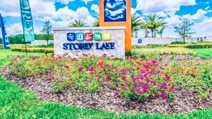 Un panneau indiquant l’emplacement de Storey Lake, orné d’icônes colorées et d’une peinture représentant un palmier.