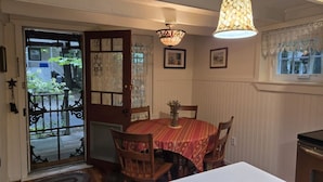 A dining area with a round table, chairs, a chandelier, and a view through a door to the outside. - Mount Gretna Magic ▪︎ 10 mins to Renaissance Faire  (Mount Gretna)