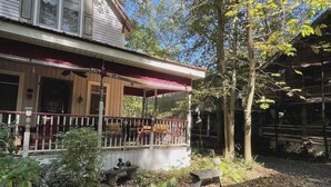 A two-story building with a covered porch and a fenced outdoor seating area. - Mount Gretna Magic ▪︎ 10 mins to Renaissance Faire  (Mount Gretna)