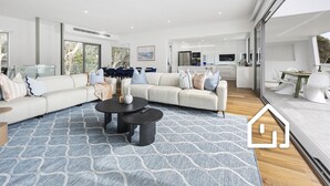 Un salon moderne avec un canapé d’angle, une table basse et un coin repas comprenant une table et des chaises.