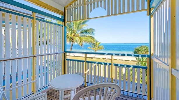 Un balcon avec vue sur la plage et l’océan.