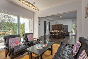 A spacious living area with a glass coffee table, leather sofas, and a view of the outdoors.