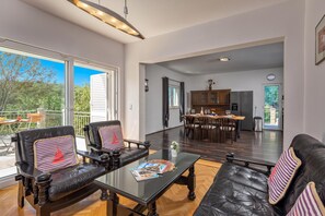 A spacious living area with a glass coffee table, leather sofas, and a dining area with wooden chairs. - Holiday Home with Pool near Makarsk, Imotski, Croatia (Imotski)