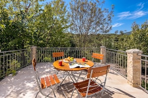 A terrace with a table set for two, surrounded by metal railings, and a stone pillar. - Holiday Home with Pool near Makarsk, Imotski, Croatia (Imotski)
