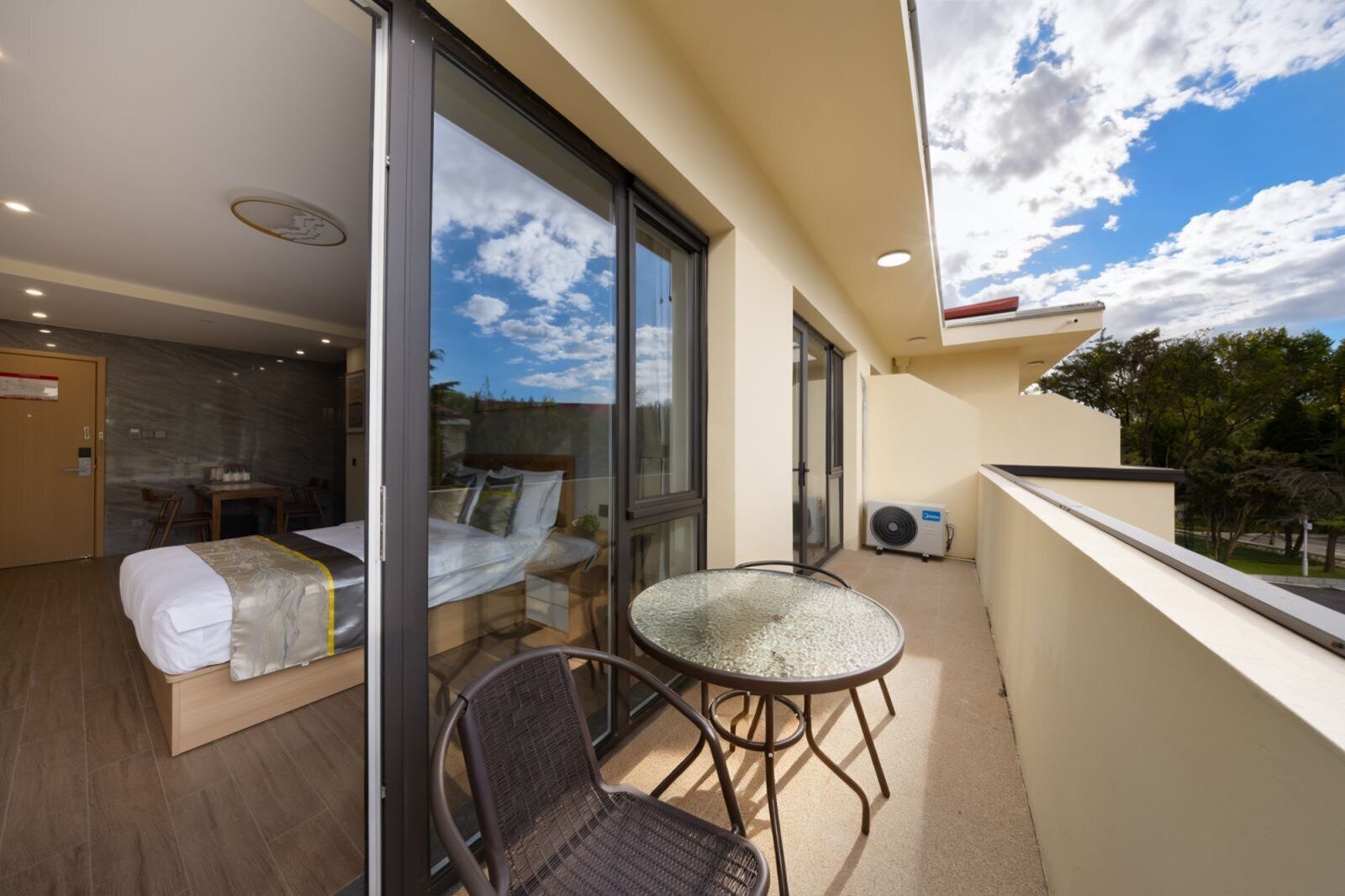 Een balkon met een bed, een tafel en stoelen.