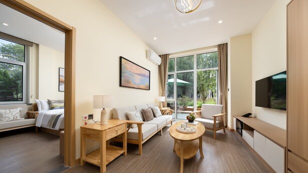 A modern living room with a sofa, coffee table, and TV. - Qinhuangdao Beidaihe Yijing Hotel (Qinhuangdao)