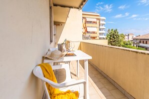 A balcony with a table set for two, a chair, and a bottle of champagne. - Casa Gialla, Alghero, Italy (Alghero)