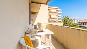 Un balcone con un tavolo, una sedia e una bottiglia di champagne.