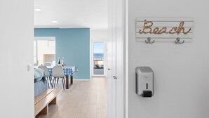A hotel room with a bed, a small table with chairs, a blue wall, and a beach-themed sign on the wall. - GuestReady - Relaxing escape near the beach (Moledo)