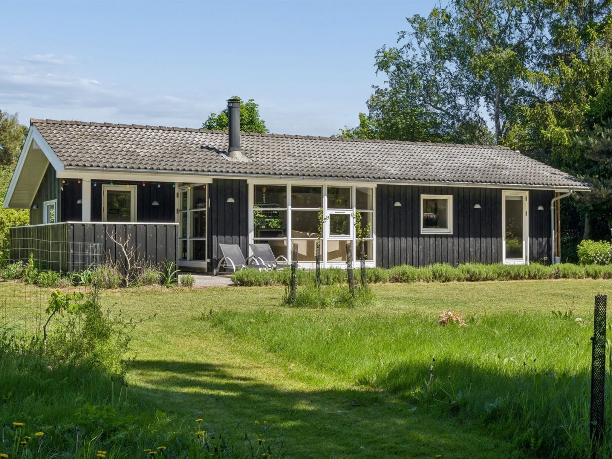 A house with a covered porch, a chimney, and a fenced yard.