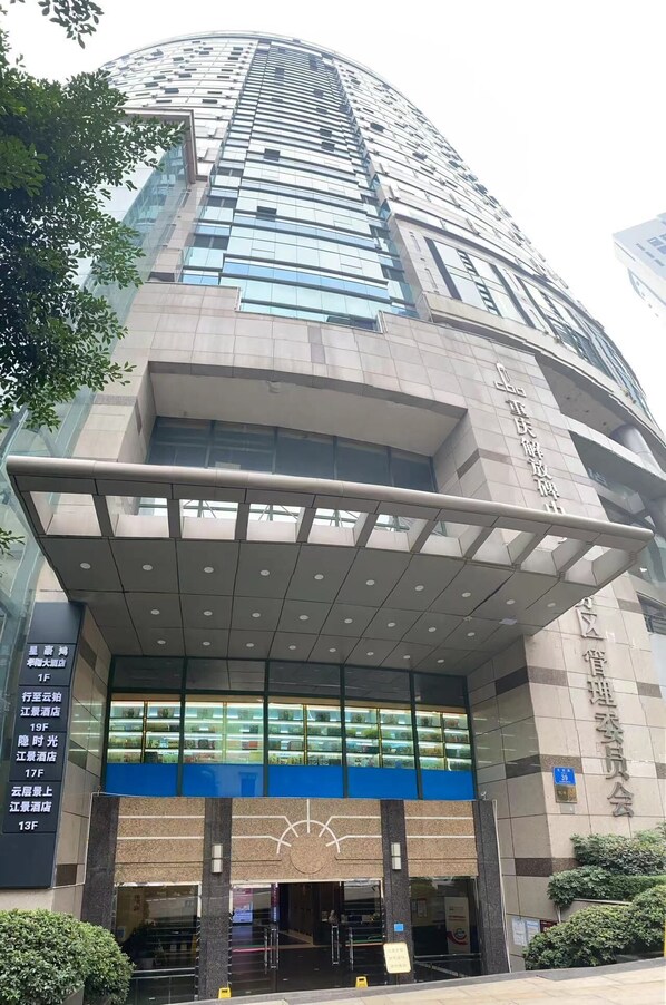 A modern building with a curved facade, large glass windows, and a prominent entrance with a canopy. - Xingzhi Yunbo Riverview Hotel (Chongqing Jiefangbei Hongyadong Branch) (Chongqing)