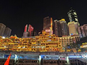 A brightly lit hotel with multiple floors and balconies, featuring a traditional architectural style with ornate decorations. - Xingzhi Yunbo Riverview Hotel (Chongqing Jiefangbei Hongyadong Branch) (Chongqing)