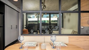 Un comedor con una mesa dispuesta para dos, un ventanal con vistas a la ciudad y un diseño de interiores moderno.