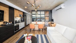 Una cocina moderna con comedor, un sofá blanco y un amplio ventanal.