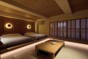 Une pièce de style japonais traditionnel, avec un sol recouvert de tatamis, une petite table en bois et deux tatamis servant de coussins.