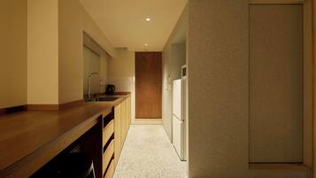 A modern kitchen with a wooden countertop, a sink, and a refrigerator.