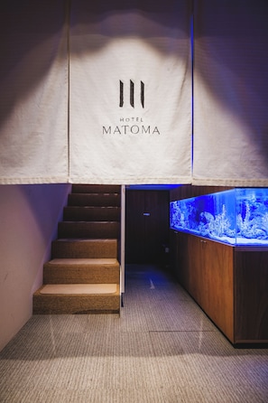 A staircase leading to a room with a large aquarium. - Hotel Matoma (Tokyo)