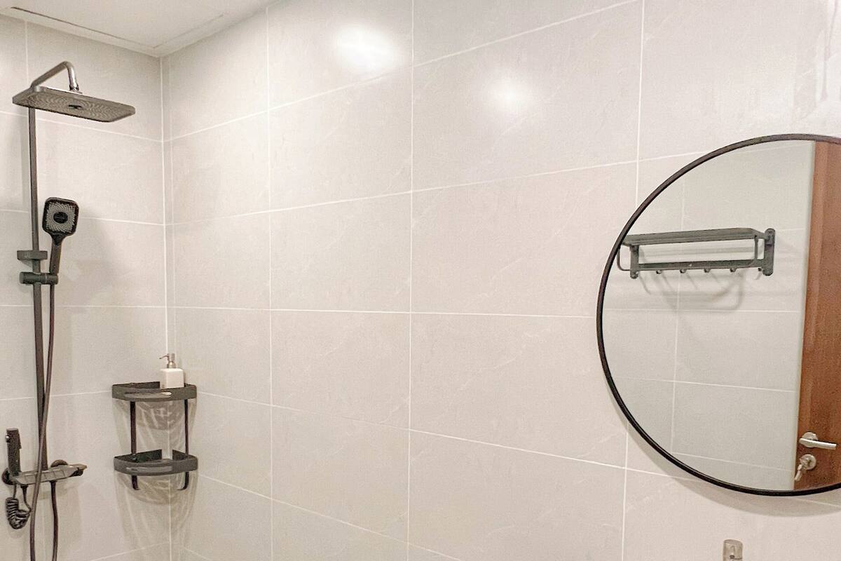 Ein modernes Badezimmer mit Dusche, Waschbecken und Spiegel.