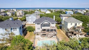 Un quartier résidentiel avec des maisons, une piscine et une vue sur l’océan.