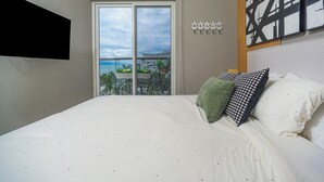 Un dormitorio con una cama grande, vistas al balcón y un cuadro en la pared.