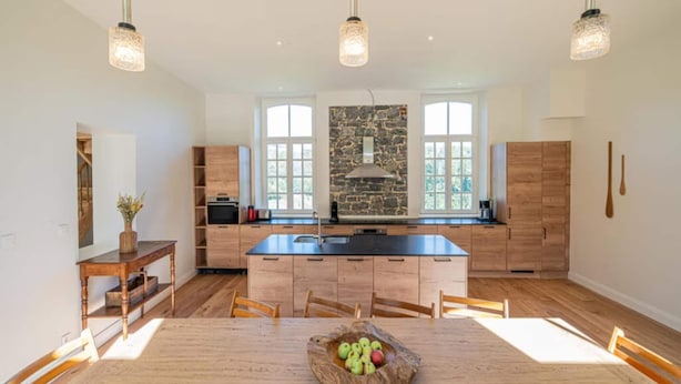 A modern kitchen with a central island, wooden cabinetry, and pendant lighting. - 3-bedroom Holiday Home With Panoramic View (Gesves)