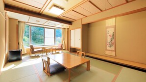Una habitación tradicional japonesa con suelo de tatami, una mesa baja y puertas correderas.