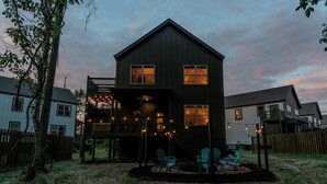 Une maison à deux étages, dotée d’un balcon et d’une terrasse, entourée d’une clôture en bois.