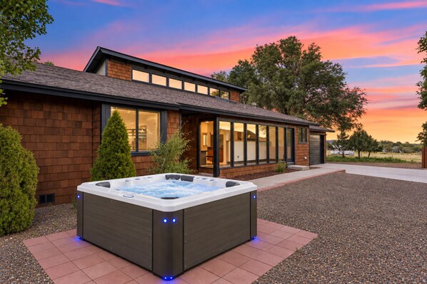 Una casa moderna con jacuzzi en el jardín delantero.