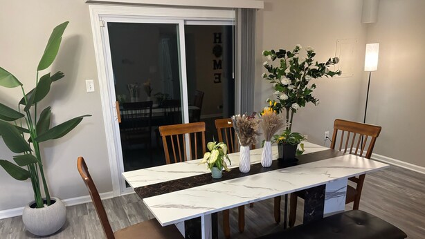 A dining area with a marble table, wooden chairs, a bench, and potted plants. - Hampton vacation home near Langley AFB (Hampton)