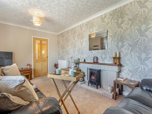 A living room with a fireplace, a television, and a sofa.