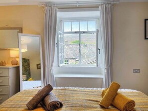 A bedroom with a bed, a window with curtains, a dresser, and a mirror. - Lock Heather Cottage (Healaugh, near Reeth)