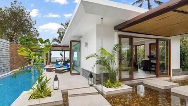 A modern house with a swimming pool, outdoor seating, and a covered patio area.