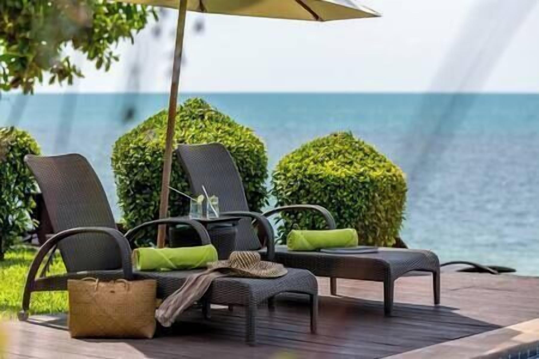 A deck with two lounge chairs, a small table, and a woven basket.