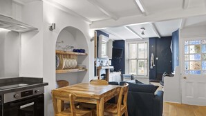 A compact kitchen with a dining area, a built-in oven, and a TV.