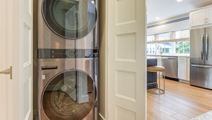 Eine moderne Küche mit Edelstahlgeräten, einem Backofen mit Platz für zwei Auflaufformen und einem großen Fenster für viel Tageslicht.