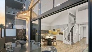 Ein modernes Interieur mit Essbereich, Küche und Treppe.
