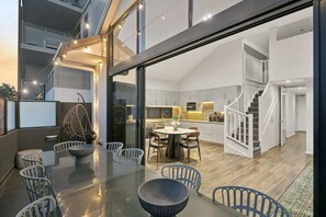 Un interior moderno con zona de comedor, cocina y escalera.
