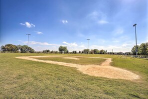 Ein Baseballfeld mit blauem Himmel und einem Sandplatz.