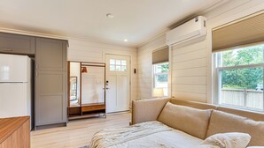 A bedroom with a bed, a wardrobe, a door, and a window.