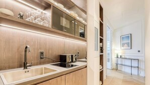 A modern kitchen with a large sink, built-in microwave, and wooden cabinetry.