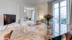 A spacious living room with a marble coffee table, a television, and a sofa.