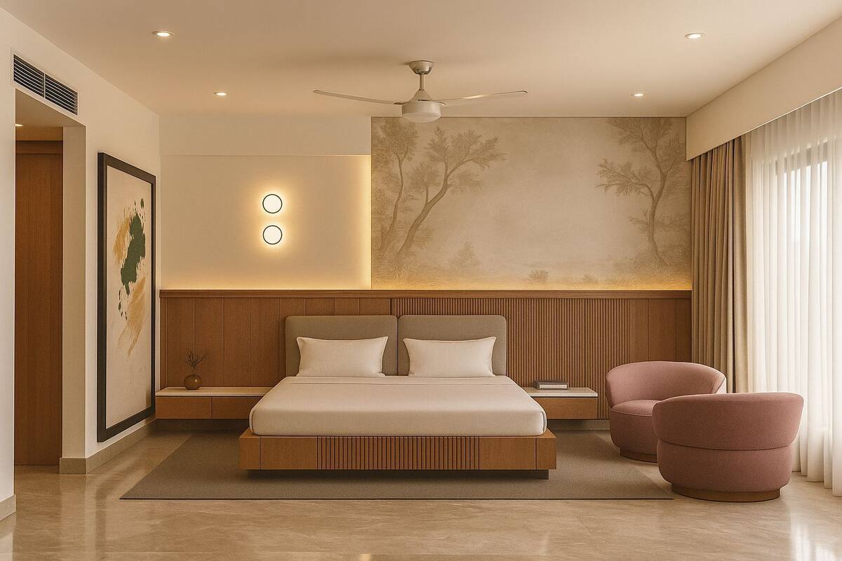 A modern bedroom with a large bed, a ceiling fan, a nightstand, a chair, and a wall with a tree mural.
