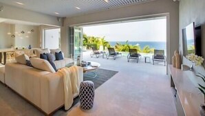 Un salon moderne avec un canapé, une table basse et une vue sur l’océan.